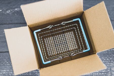 online orders conceptual still-life, shopping basket inside open delivery parcel