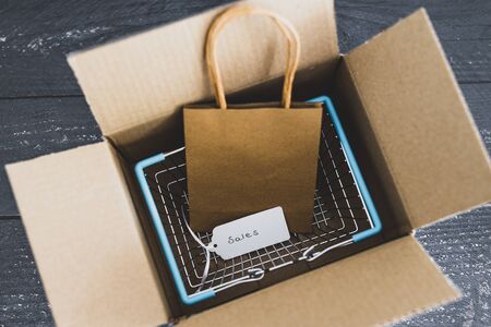 online orders conceptual still-life, shopping basket inside open delivery parcel with sales price tagの写真素材