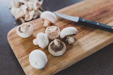 white porcini mushrooms chopped on cutting board with knife, concept of homecooking and meal preppingの写真素材