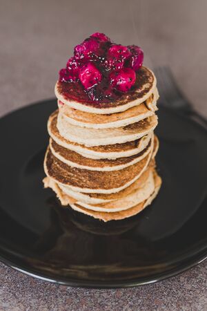 healthy plant-based recipes concept, vegan banana pancakes stack with exotic dragonfruit coulis on...