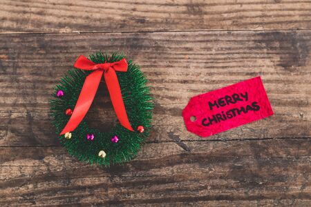 festive season's decorations conceptual still-life, Christmas  wreath and Merry Xmas label next to itの写真素材