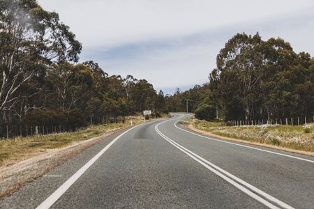 Australian countryside road trip view from the car with empty road and eucalyptus bush, taken in Tasmania driving along the Eastern Coastの写真素材