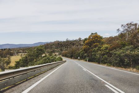 Australian countryside road trip view from the car with empty road and eucalyptus bush, taken in Tasmania driving along the Eastern Coastの写真素材