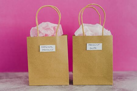 original product vs dupe imitation conceptual still-life, shopping bags with labels side by side...