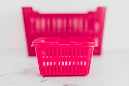 big vs small budget conceptual still-life, different size shopping baskets next to each otherの写真素材