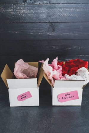 big vs small budget conceptual still-life, different size price tags on delivery parcels