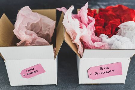 big vs small budget conceptual still-life, different size price tags on delivery parcelsの写真素材