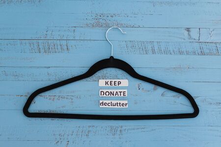 tidying up and decluttering conceptual still-life, clothes hangers with text labels to sort between objects to keep donate or declutterの写真素材