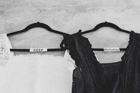 tidying up and decluttering conceptual still-life, clothes hangers with black and white tops and...