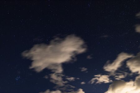 starry night with crisp sky and some clouds with a lot of constellations visible as well as some...