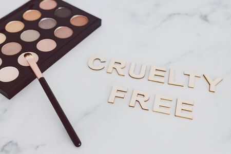 beauty industry and vegan products conceptual still-life, make-up brushes and eyeshadow palette with Cruelty free text next to them referring to the use of synthetic bristle and items not tested on animalsの写真素材