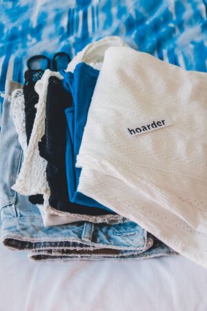 tidying up and de cluttering conceptual illustration, Hoarder vs Minimalist clothes pile with text labelsの写真素材
