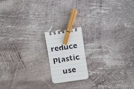 sustainable living conceptual still-life, Reduce plastic use message with wooden pegs to hang the...