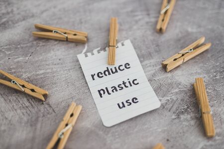 sustainable living conceptual still-life, Reduce plastic use message with wooden pegs to hang the...