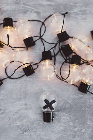 decision making conceptual still-life, bad idea rejected and crossed out surrounded by other light bulbs lit upの写真素材