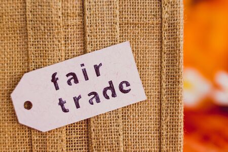 ethical shopping and locally sourced items conceptual still-life, close-up of small canvas bag made of natural materials with Fair Trade text on price tagの写真素材