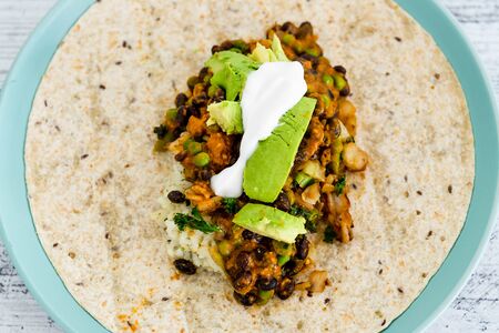 healthy blant-based recipes concept, beans rice and avocado open wrap with vegan aioliの写真素材