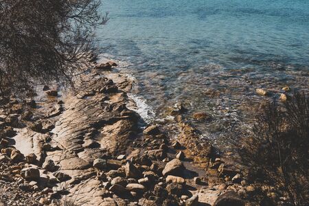 detail of Blackman's Bay beach and its rocky coastline on a sunny summer day in the late afternoon before dusk, the area is one of the most popular beaches near the city of Hobartの写真素材