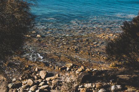 detail of Blackman's Bay beach and its rocky coastline on a sunny summer day in the late afternoon...