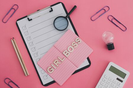 equal opportunity and fairness in society conceptual still-life, Girl Boss text on top of pink notebook on business office desk with to do list and mixed stationery on pink backgroundの写真素材