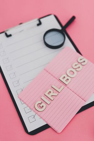 equal opportunity and fairness in society conceptual still-life, Girl Boss text on top of pink notebook on business office desk with to do list and mixed stationery on pink backgroundの写真素材