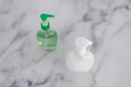 hygiene and protecting from viruses and bacteria, hand sanitizer and liquid soap bottle on marble bathroomの写真素材
