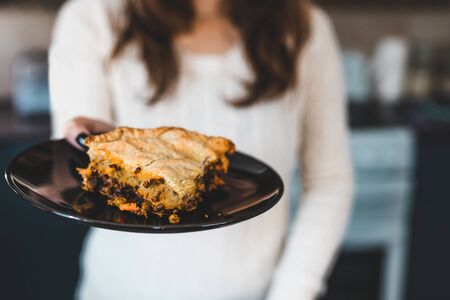 healthy homemade plant-based food recipes, woman holding piece of vegan lentil and nutritional yeast...