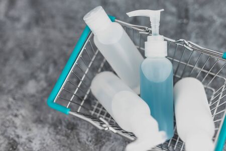 importance of hygiene to slow the spread of germs and viruses, shopping basket fully of mixed sanitizers and cleaning supplies symbol of cleaning hands and surfaces to flatten the curveの写真素材