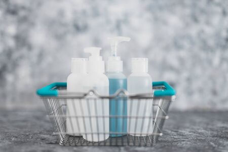 importance of hygiene to slow the spread of germs and viruses, shopping basket fully of mixed sanitizers and cleaning supplies symbol of cleaning hands and surfaces to flatten the curveの写真素材