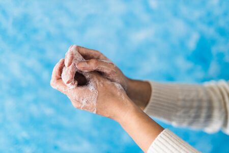 flattening the curve through hygiene against pandemic outbreaks like covid-19, detail of soapy hands showing hand washing gesturesの写真素材