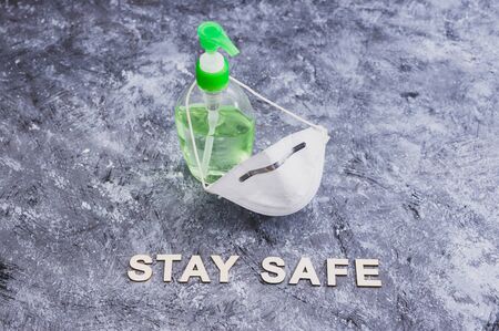 hygiene against viruses outbreak like covid-19 and other bacteria, hand sanitizer and face mask side by side with stay safe messageの写真素材