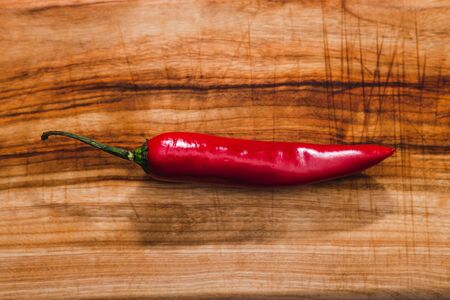 healthy plant-based food ingredients concept, red chili pepper on wooden cutting board
