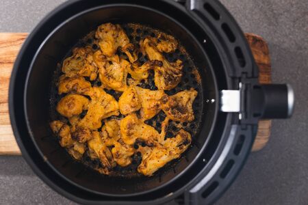 healthy plant-based food recipes concept, vegan buffalo cauliflower florets in air fryer basketの写真素材