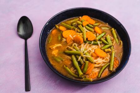 healthy plant-based food recipes concept, vegan carrot and green beans soup with vegetable brothの写真素材