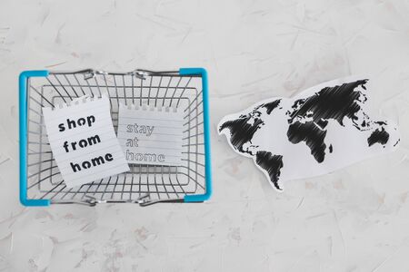 helping businesses after the global lockdown caused by covid-19, shopping bags and world map with Shop from home and Stay Home messageの写真素材