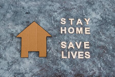 social distancing against covid-19 virus, Stay Home message with hand holding house icon next to textの写真素材