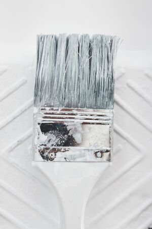DIY and home improvement concept, close-up of paint tray with white glossy paint and paint brush on itの写真素材