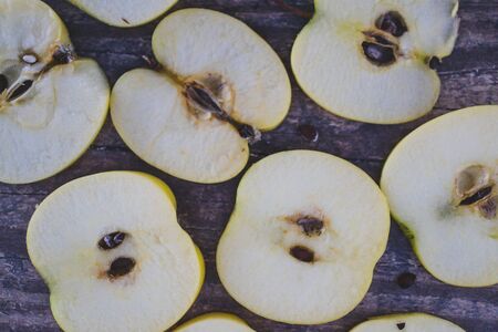 healthy plant-based food ingredients concept, apple halves on wooden tableの写真素材