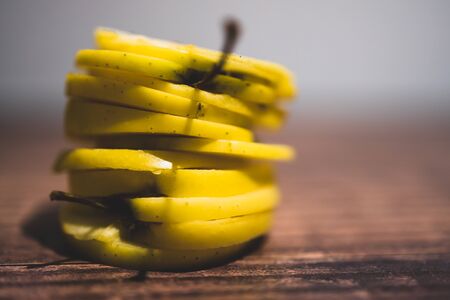 healthy plant-based food ingredients concept, yellow apples cut into stacked slicesの写真素材