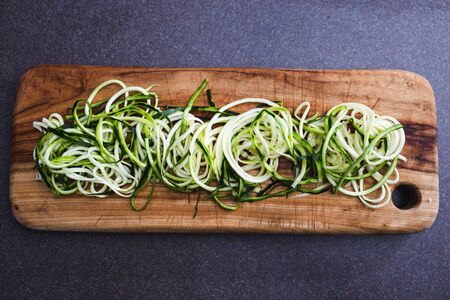 simple food ingredients concept, zucchini noodles on wooden cutting boardの写真素材