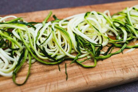 simple food ingredients concept, zucchini noodles on wooden cutting boardの写真素材