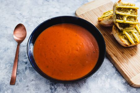 healthy plant-based food recipes concept, vegan tomato soup with pesto garlic bread with dairy-free cheese toppingの写真素材