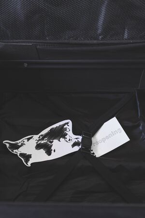 travel industry and flying during covid-19, carry-on luggage with world map and reopening memoの写真素材