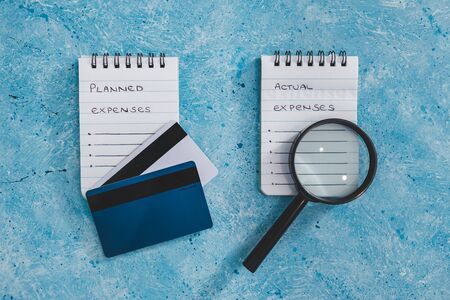 managing money and finance concept, planned expenses vs actual expenses notepads side by side with...