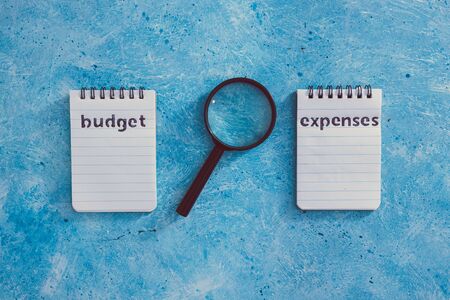 managing money and finance concept, budget and expenses notepads side by side on blue desk with...