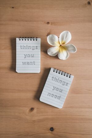 lifestyle and psychological insights concept, notepads with titles Things you need vs things you want side by side on desk ready for meditationの写真素材