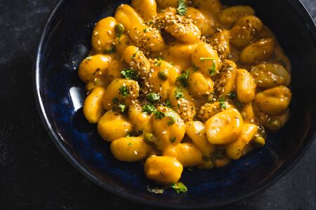 healthy plant-based food recipes concept, vegan pumpkin gnocchi with sesame seeds and corianderの写真素材