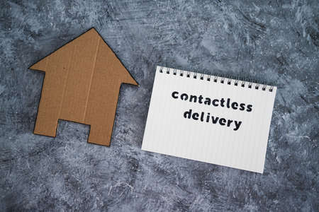 the new normal after covid-19, Contactless Delivery text on notepad with house icon concept of purchases during isolation and lockdownの写真素材