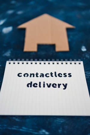 Contactless Delivery text on notepad with house icon concept of groceries shopping during quarantine or lockdownの写真素材