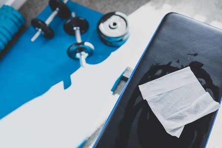 the new normal for businesses after covid-19, hand cleaning gym equipment with disinfectant wipe against virus and bacteriaの写真素材